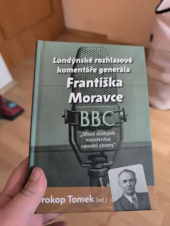 Kniha Mluví důstojník ministerstva národní obrany s portrétem generála Františka Moravce, v ruce
